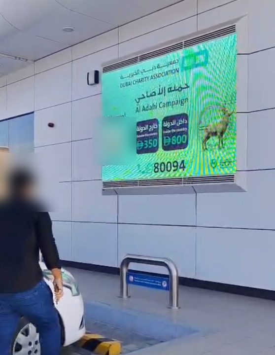 شاشة حملة الأضاحي لجمعية دبي الخيرية على جدار محطة وقود