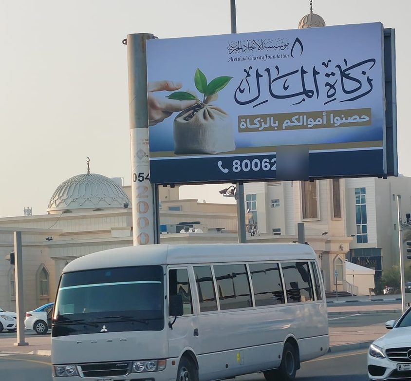 لوحة زكاة المال لمؤسسة الاتحاد الخيرية فوق شارع قرب مسجد