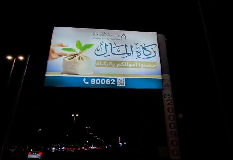 لوحة مؤسسة الاتحاد الخيرية مضاءة بجانب طريق ليلا