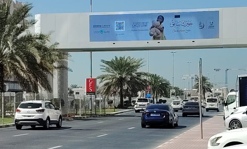 لافتة جمعية دار البر على جسر فوق الطريق