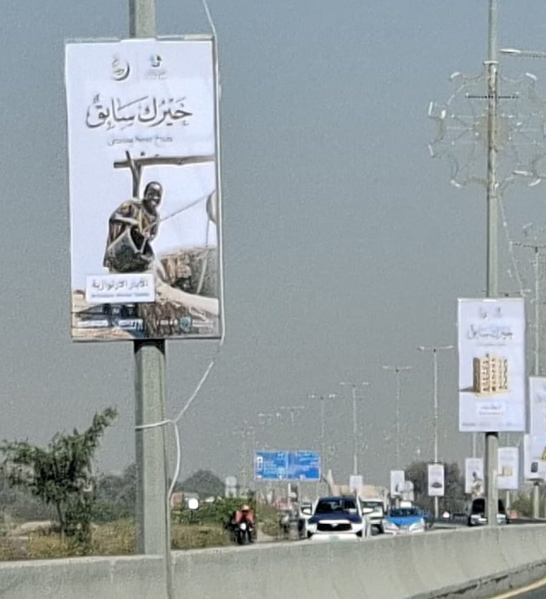 لافتات جمعية دار البر على أعمدة الإنارة بجانب طريق سريع