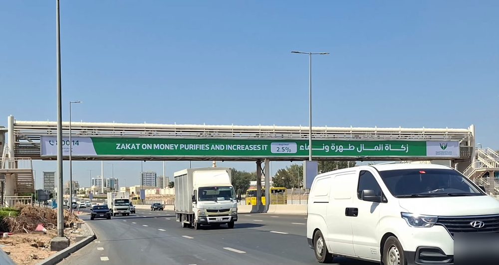 لافتة زكاة المال لجمعية الشارقة الخيرية على جسر مشاة فوق طريق