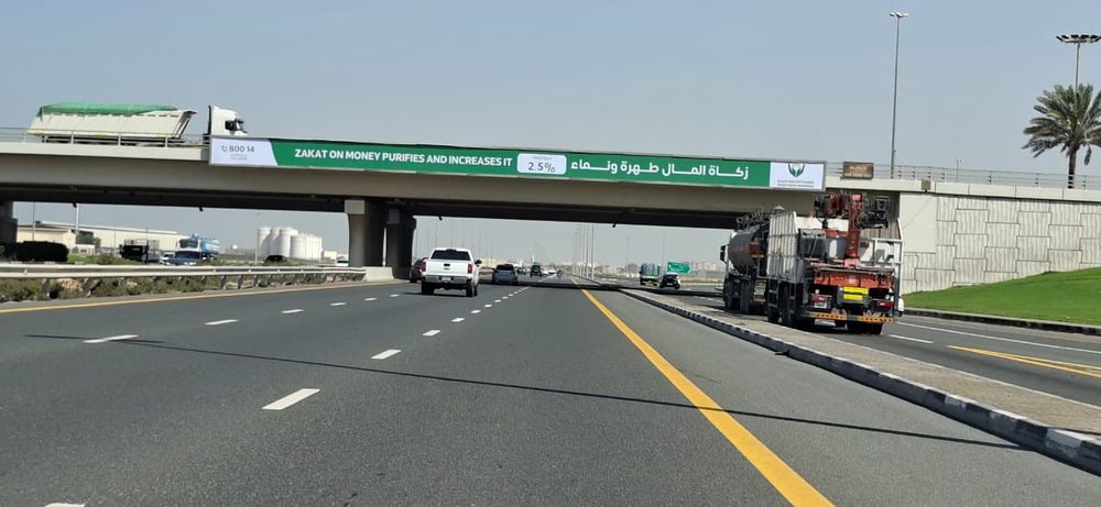 لافتة جمعية الشارقة الخيرية على جسر فوق طريق سريع